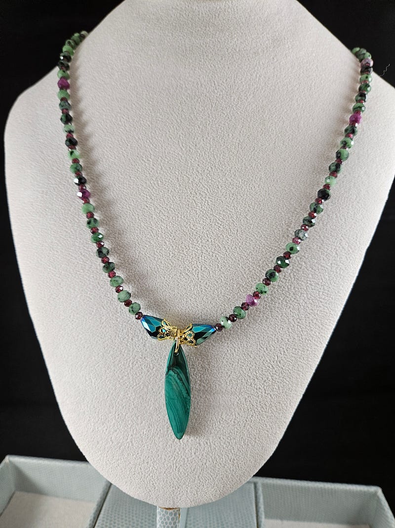 Necklace showcasing a malachite pendant and ruby zoisite beads