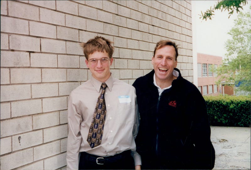 A teenage boy at a science fair with his father