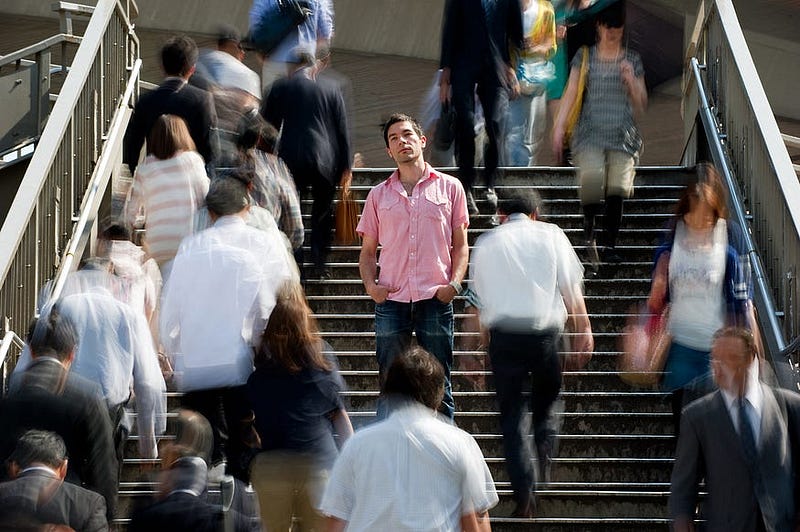 A man reflecting on self-perception amidst an audience