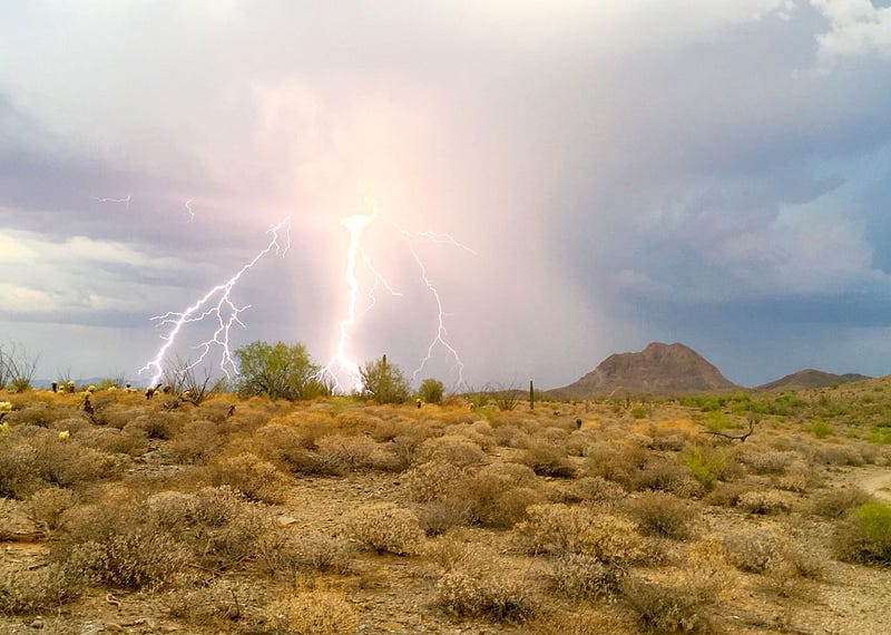 Lightning striking in the Arizona desert at sunset.